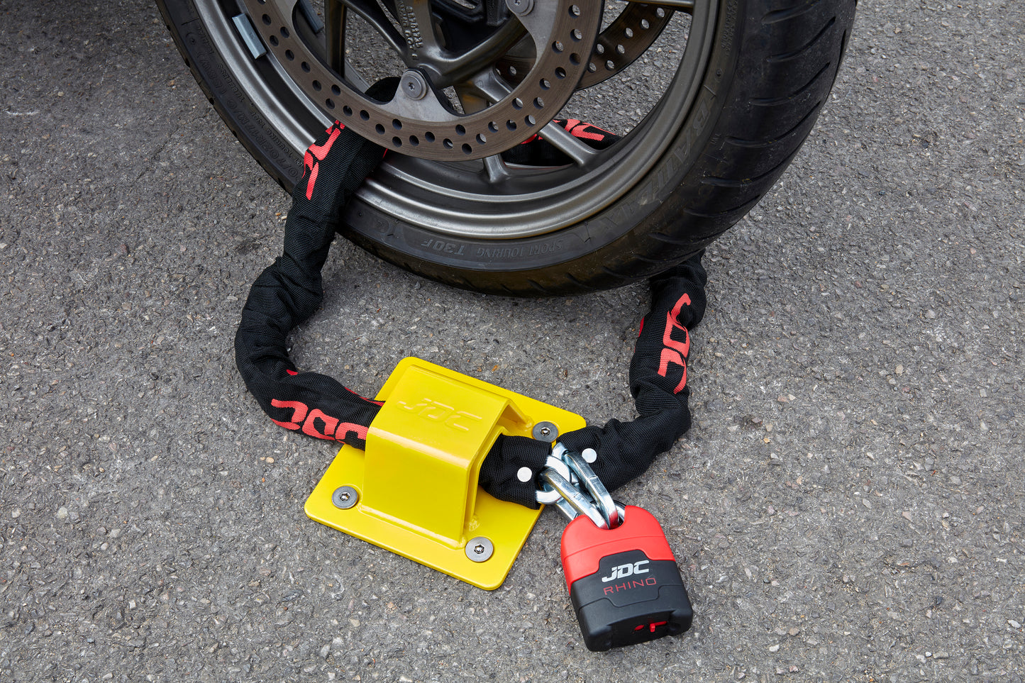 JDC Product's Sphere Pro Ground Anchor shown with JDC Heavy Duty Bike Chain securing a motorbike