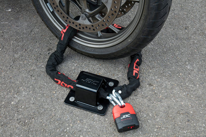 JDC Product's Sphere Ground Anchor Pro (black) shown with JDC Heavy Duty Bike Chain securing a motorcycle